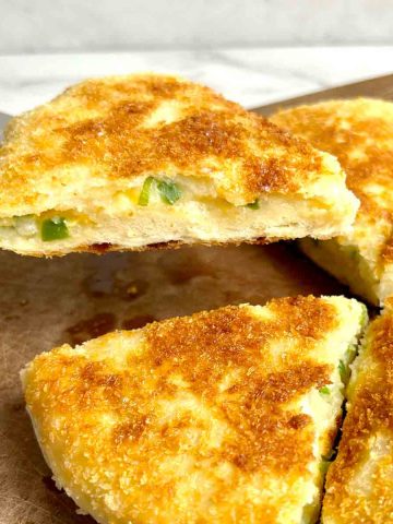 metal spatula lifting a piece of potato cheese bread.