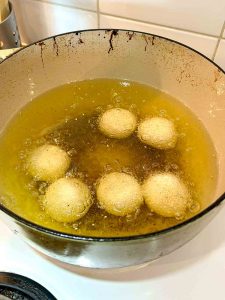 sesame balls beginning to float in oil.