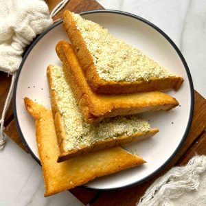 shrimp toast cut into triangles on plate.