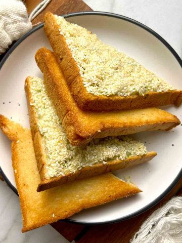 shrimp toast cut into triangles on plate.