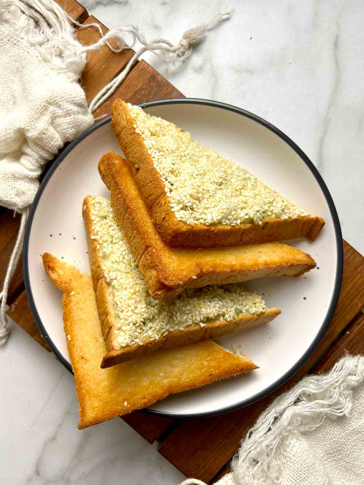 shrimp toast cut into triangles on plate.