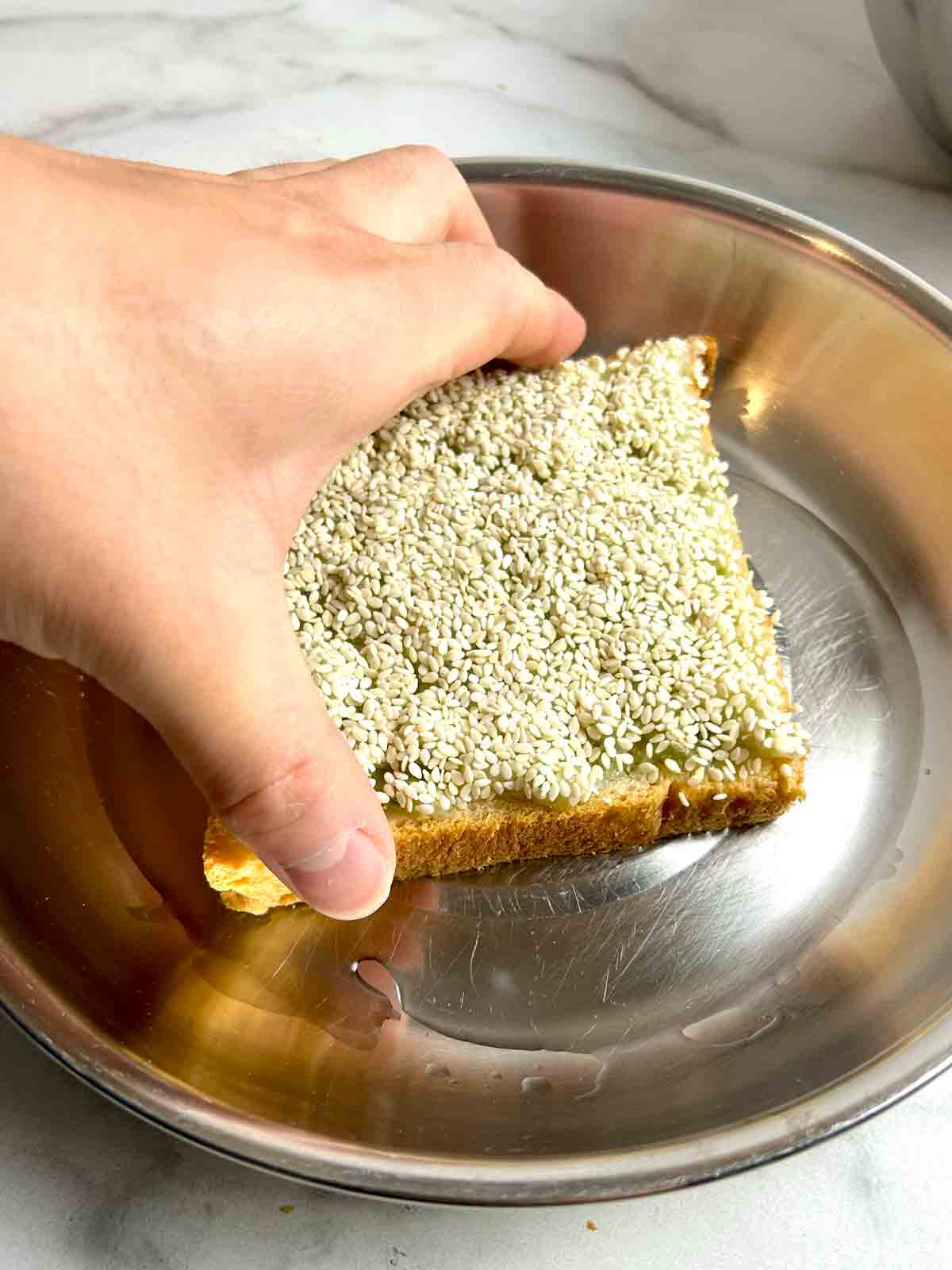 bread being smeared into plate of oil.