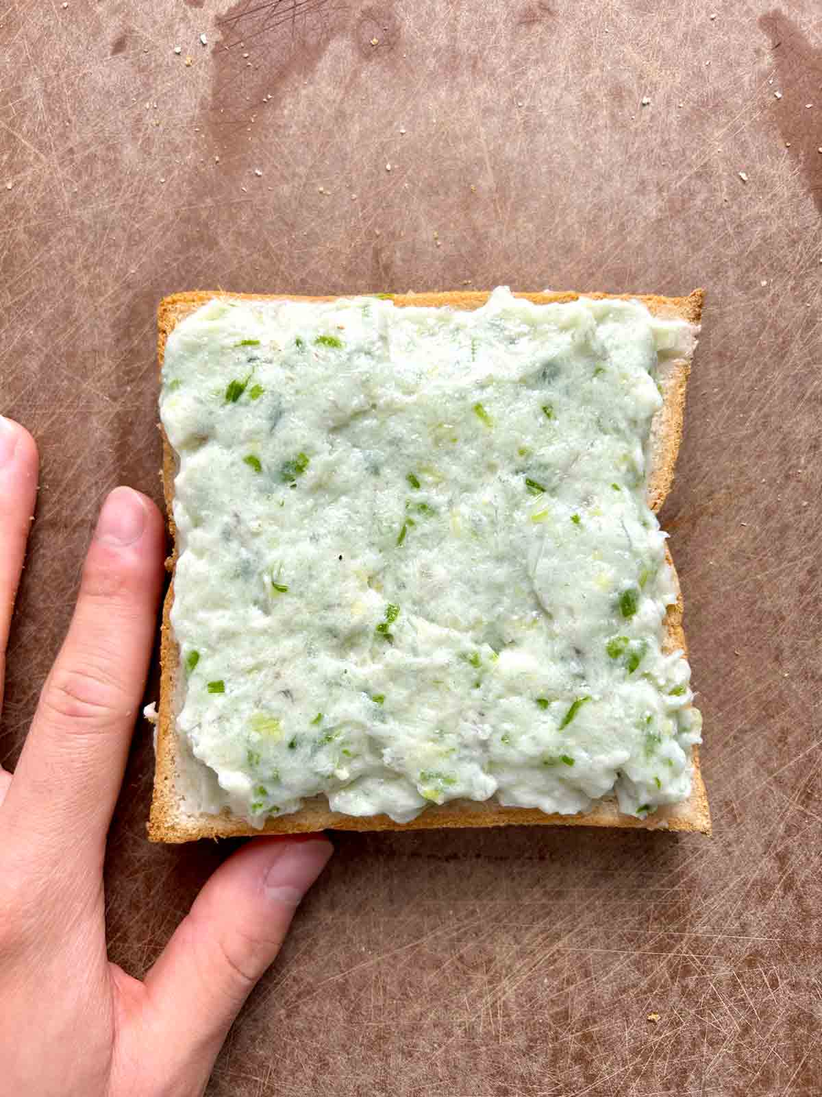 shrimp paste being spread onto slice of bread.