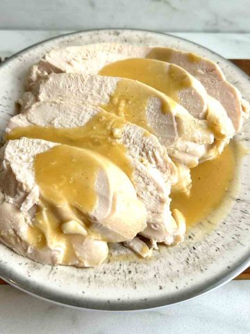 sliced turkey breasts with gravy poured on top.