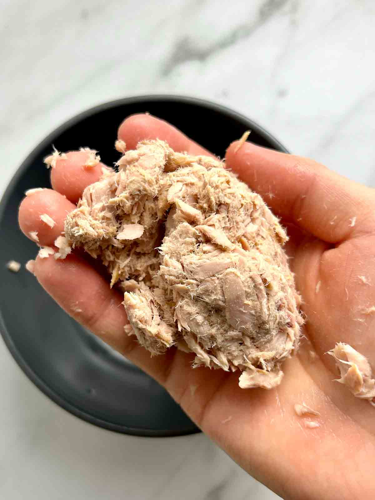 canned tuna squeezed dry in hands.