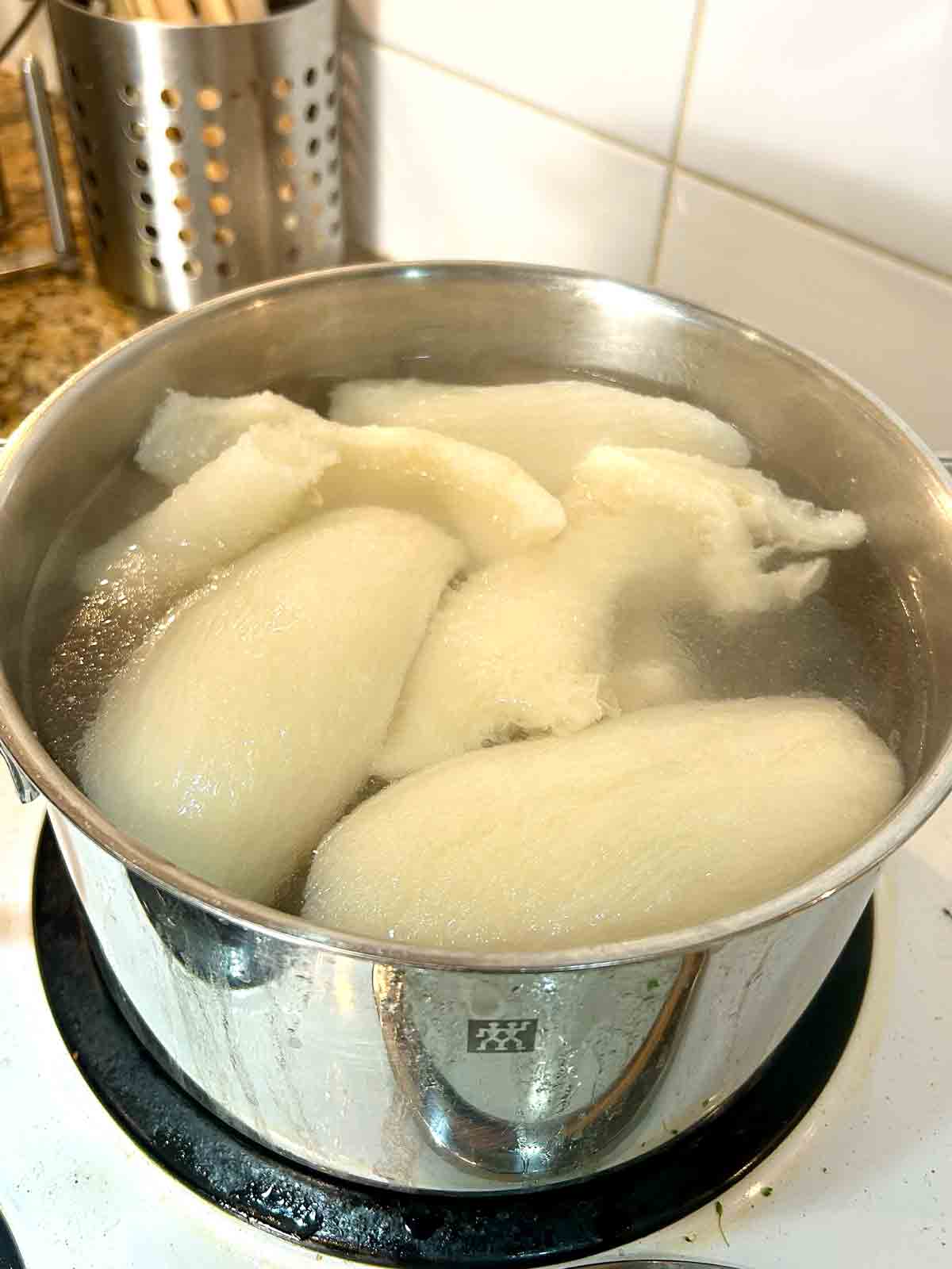 beef tripe being boiled in pot of water.