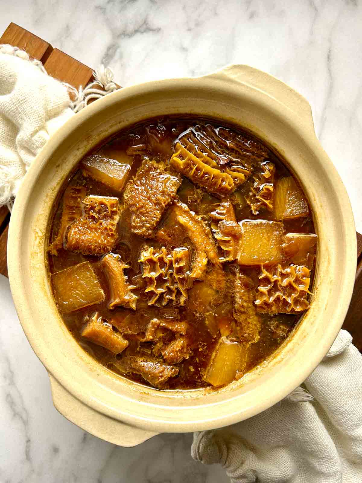 overhead shot of braised beef tripe in clay pot.