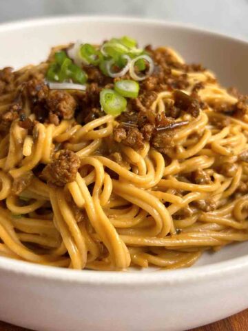 close up of dan dan noodles in bowl.