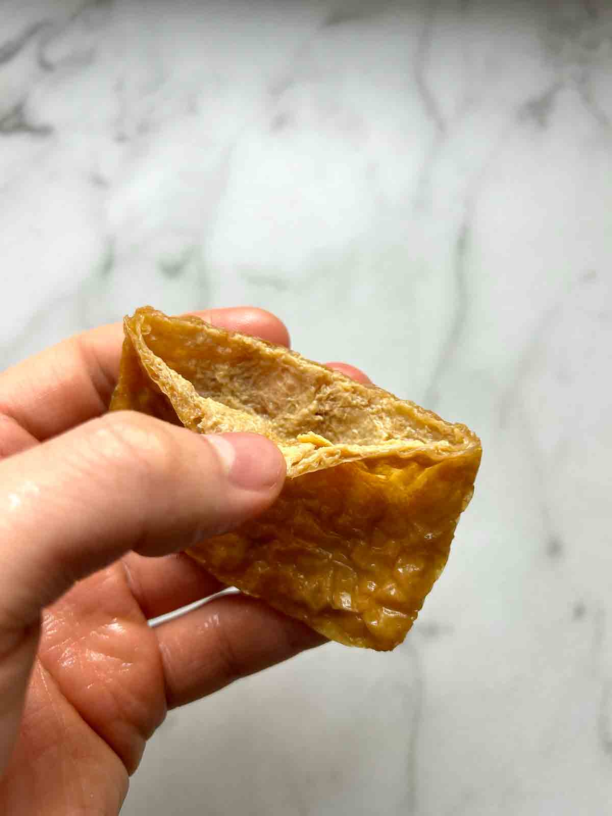 using hands to open tofu pocket.