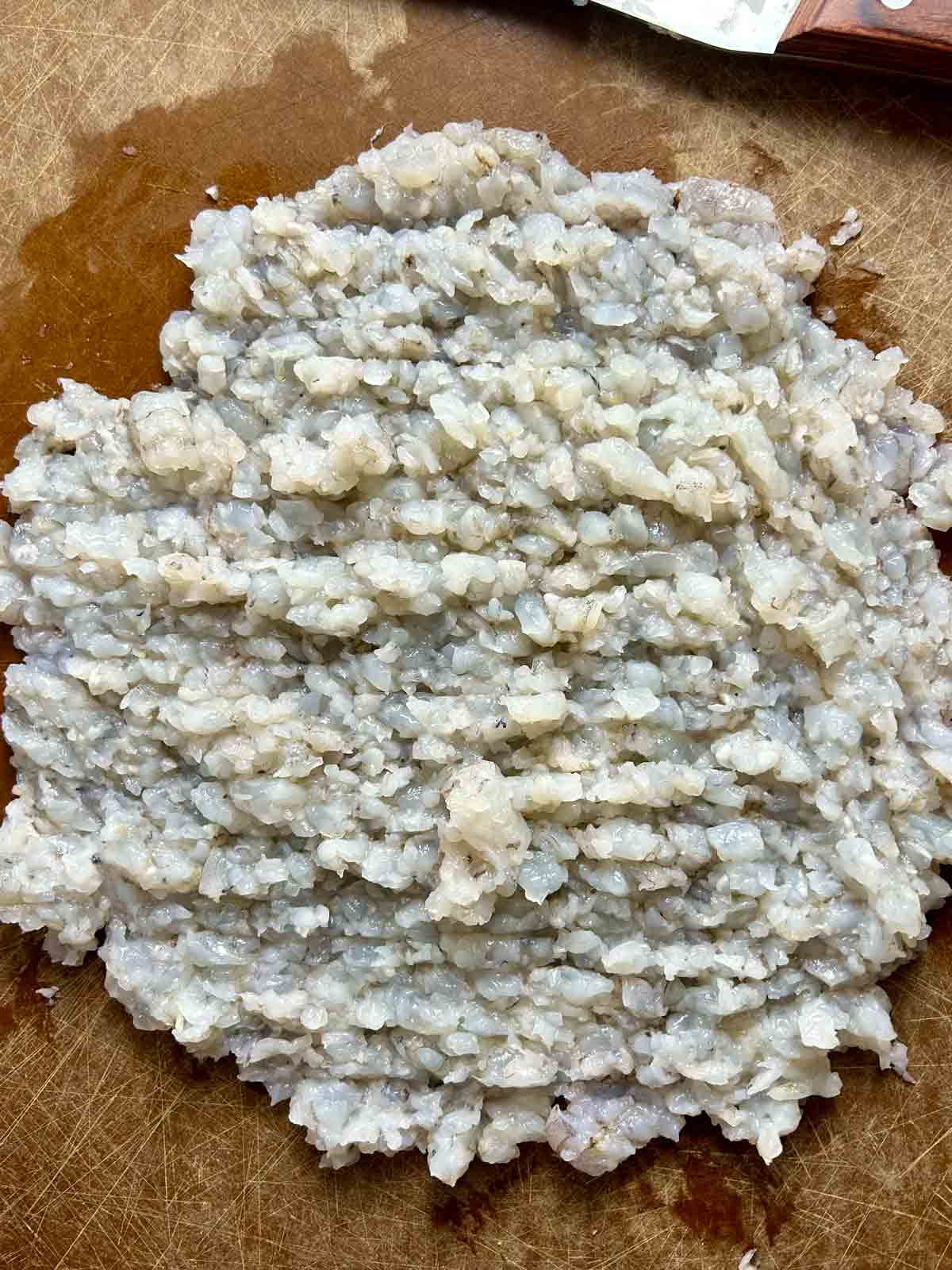 shrimp chopped to fine mince on cutting board.