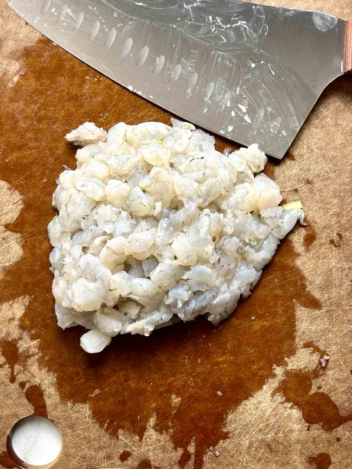 roughly chopped shrimp on cutting board.