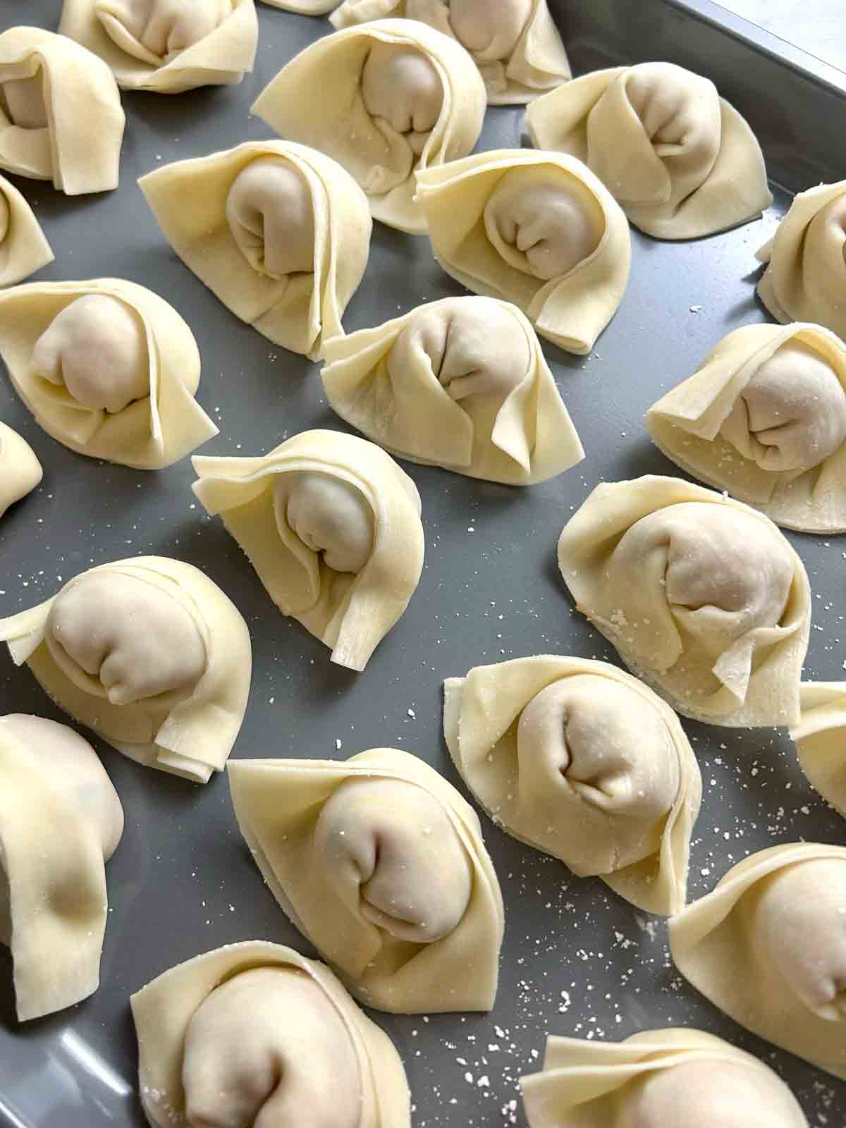 wrapped wontons on baking sheet.