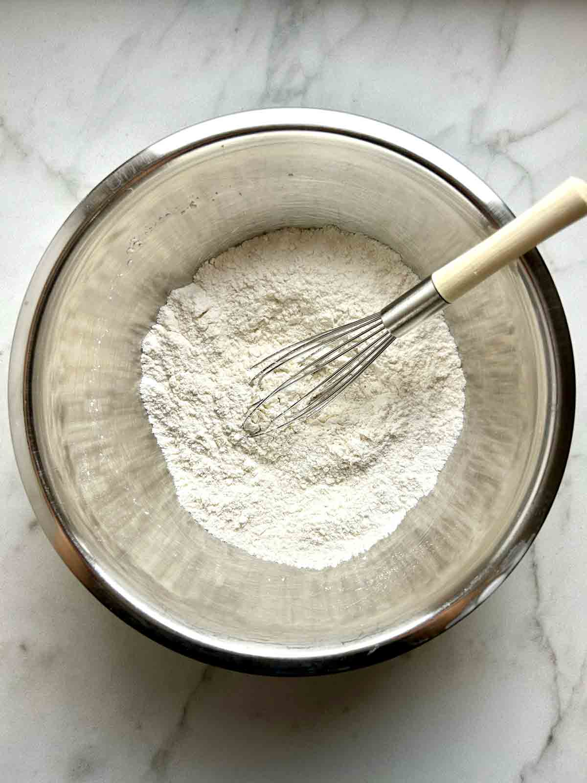dry ingredients being whisked together in bowl.