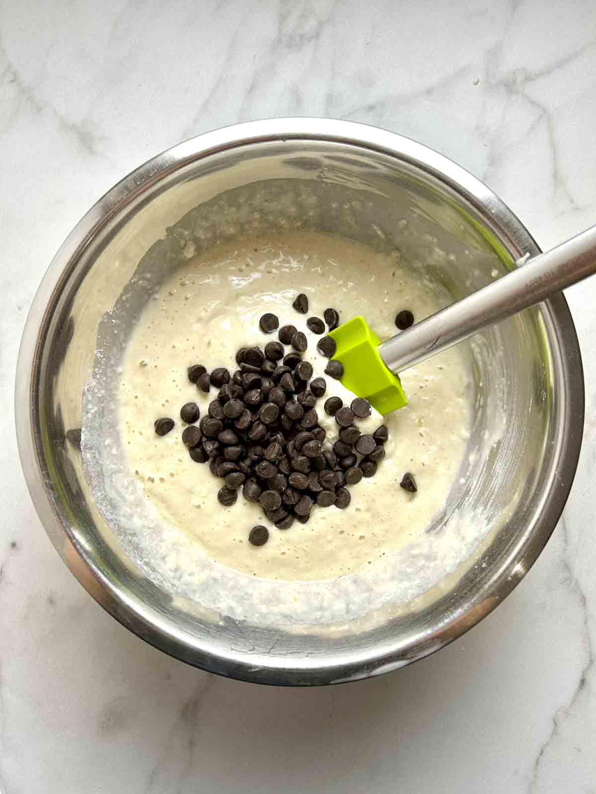 chocolate chips being folded into pancake batter.