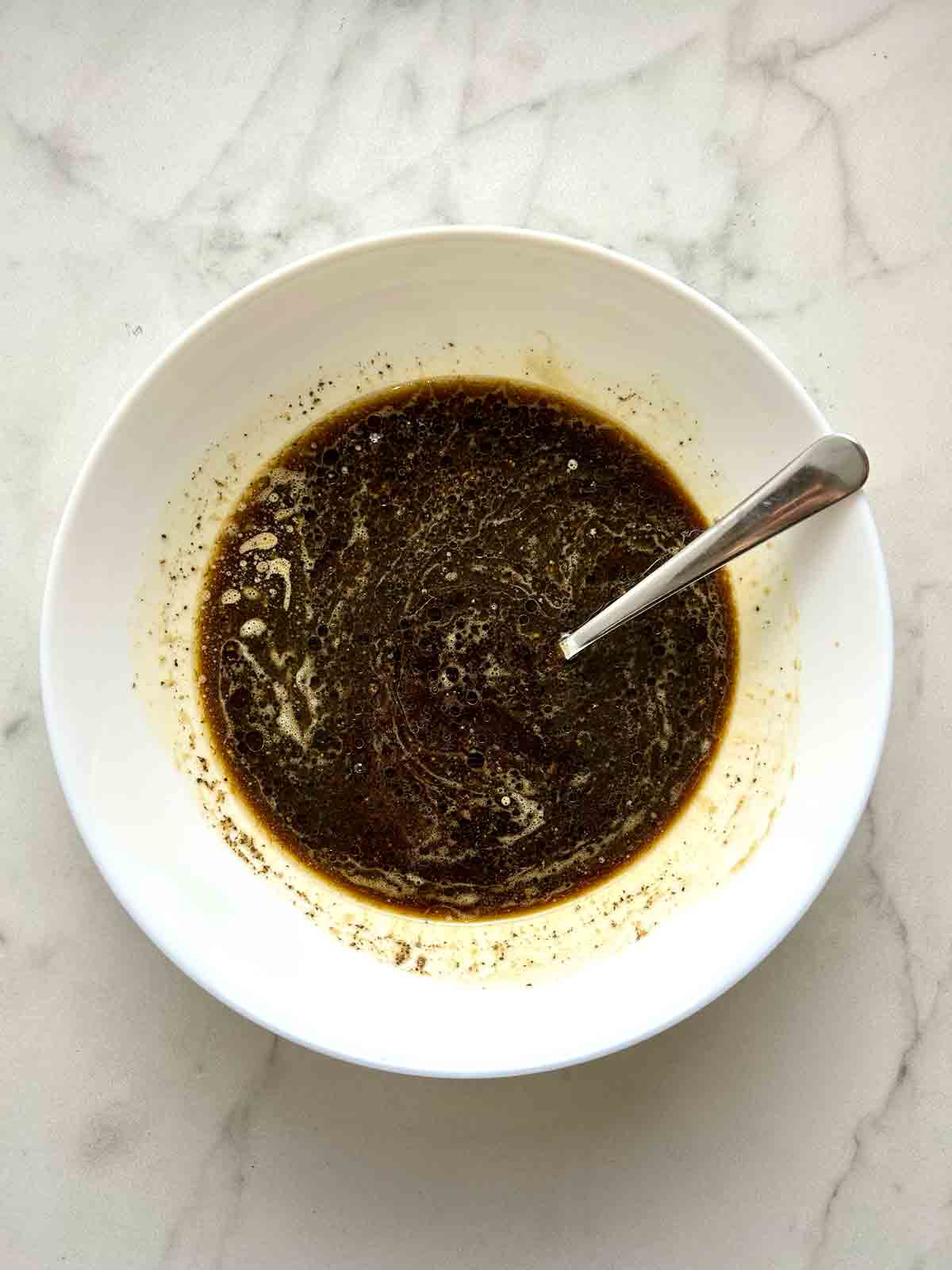 marinaded being mixed together in bowl.