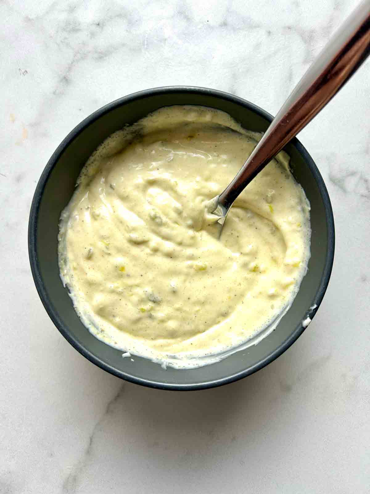 dressing being mixed in bowl.