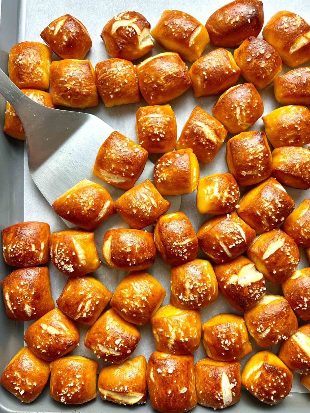 spatula lifting pretzel bites from pan.