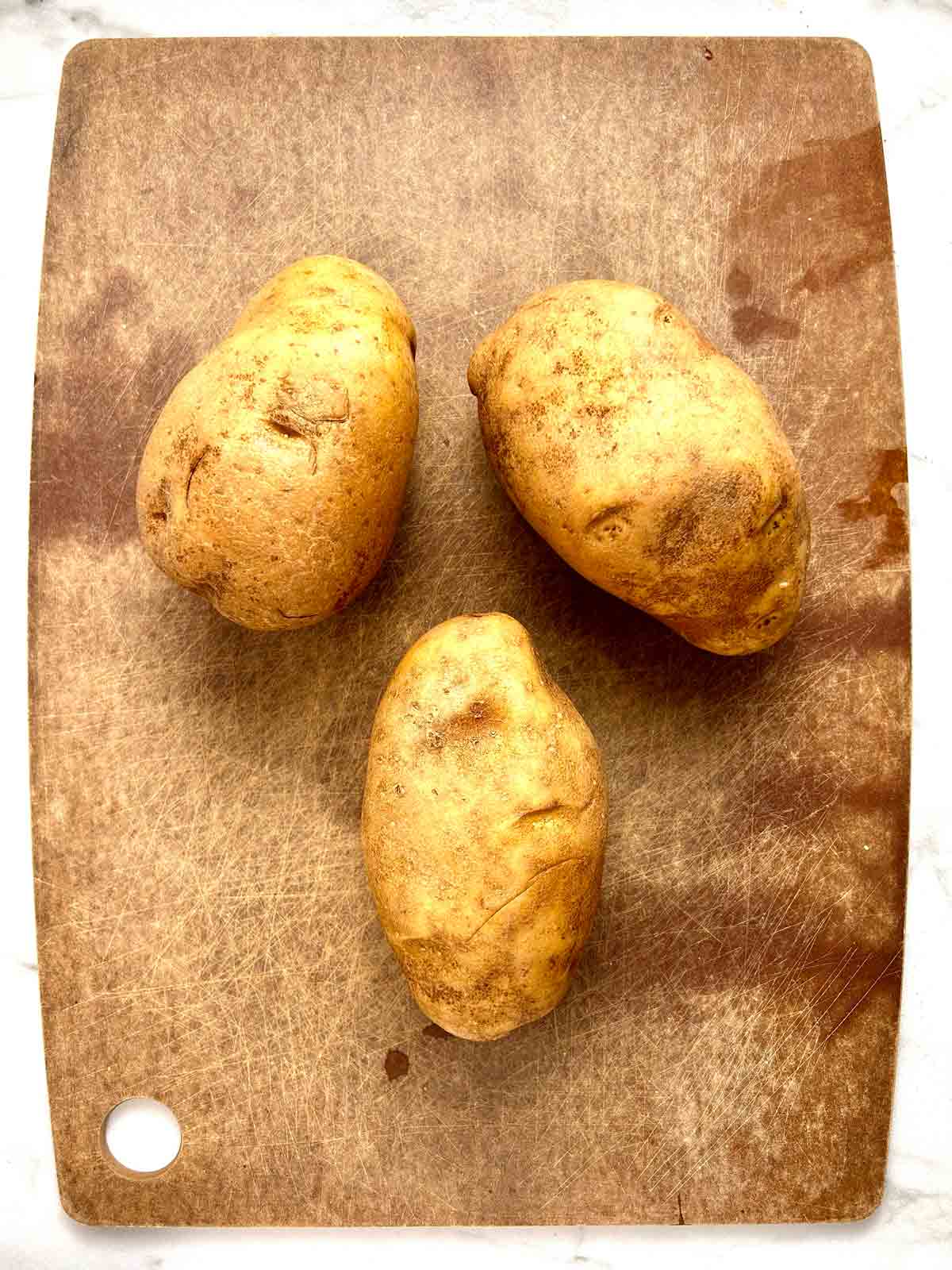 washed potatoes on cutting board.