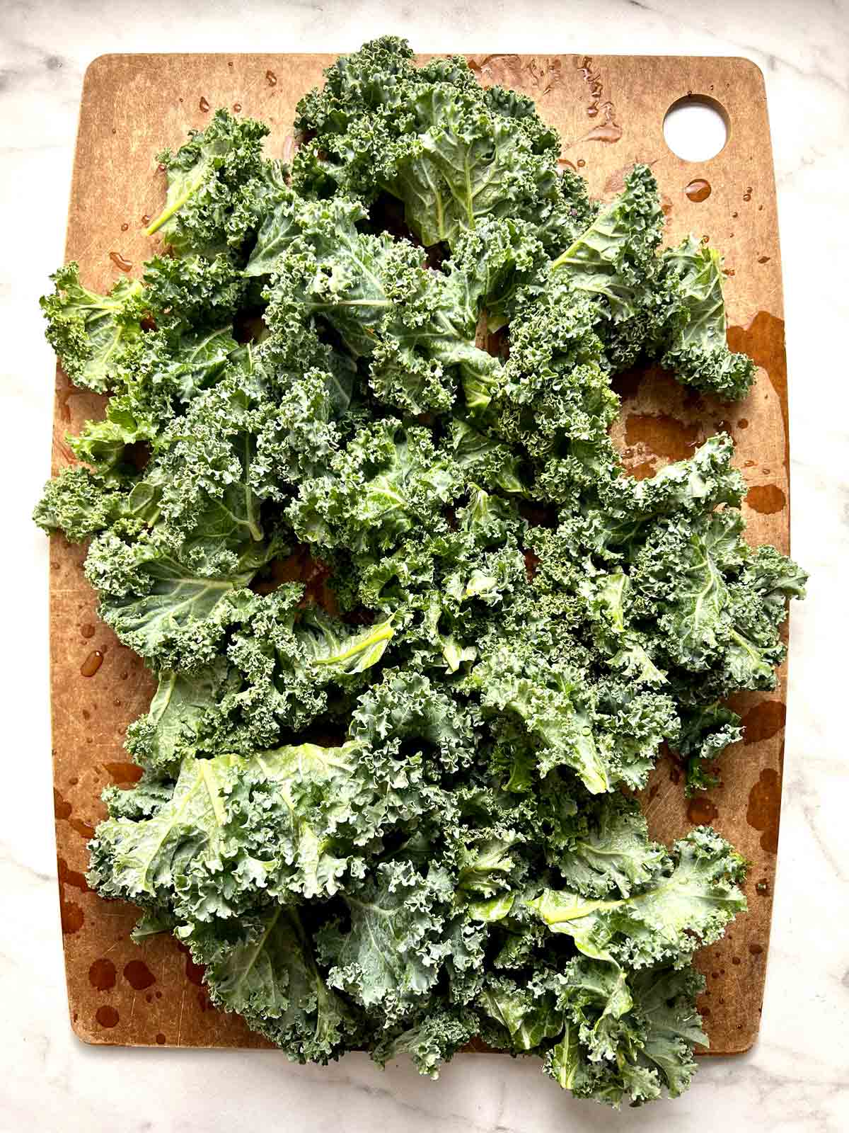 kale torn into pieces on cutting board