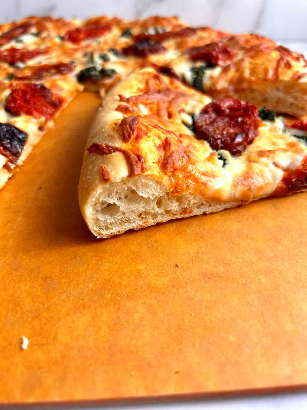 slice of pizza showing cross section of crust.