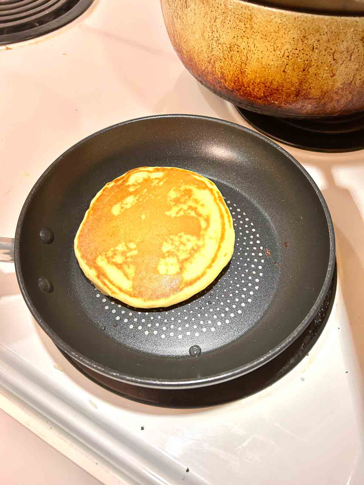 golden brown pancake in pan.