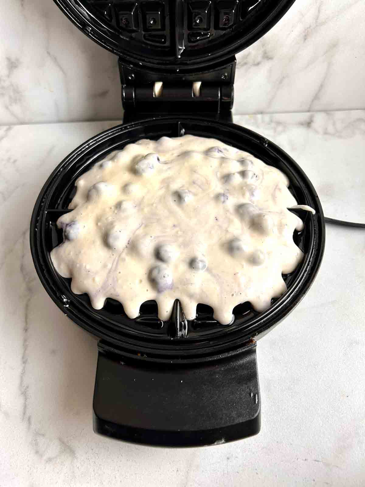 batter scooped into waffle iron.