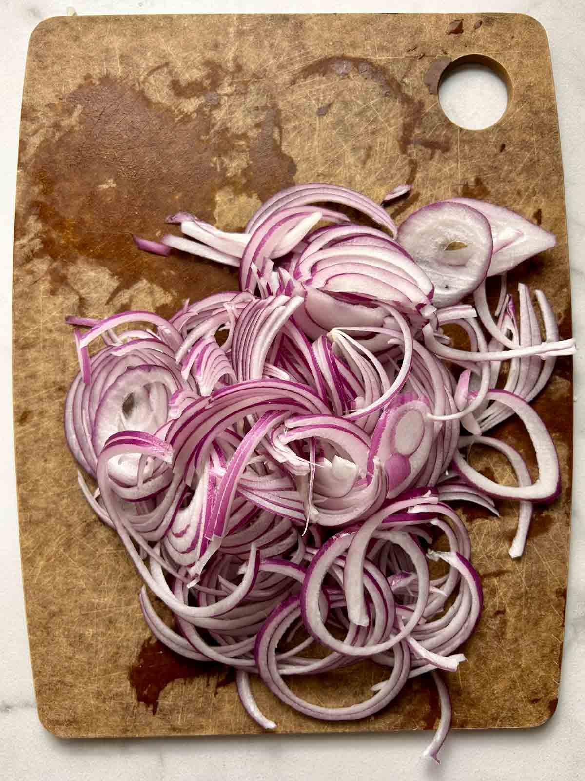 onions sliced thinly on cutting board.