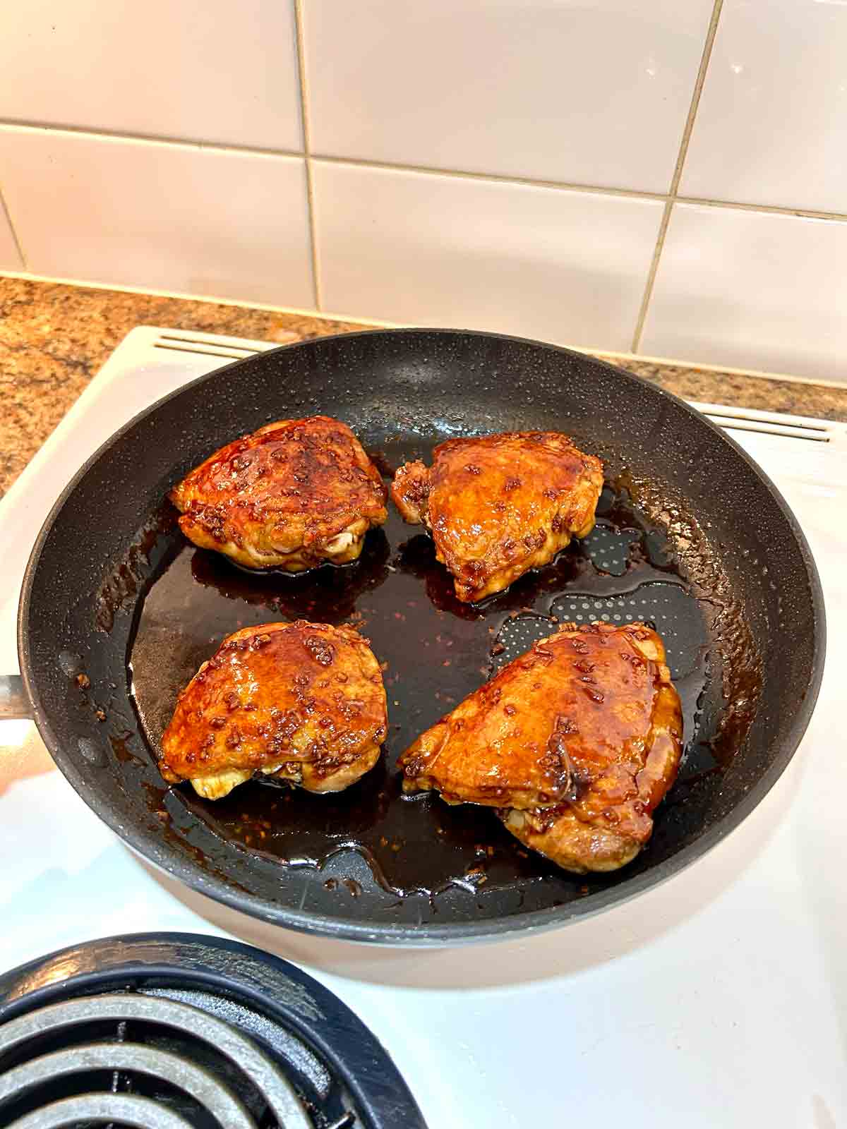 sauce being cooked with chicken thighs.