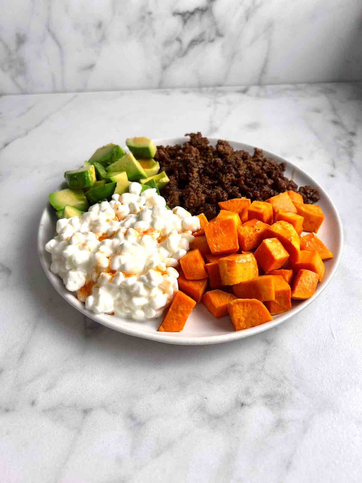 ground beef, avocado, sweet potatoes, and cottage cheese in bowl.