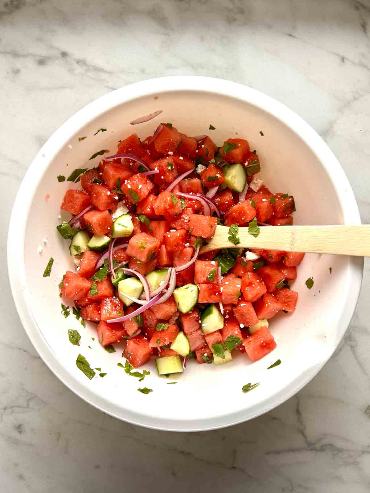 watermelon salad mixed together in bowl.