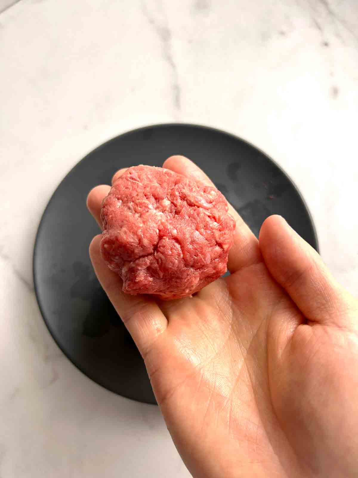 beef shaped into ball in hand.