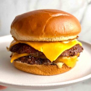 smash burger with cheese on plate.