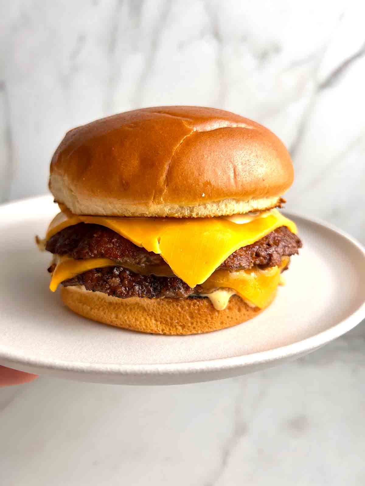 smash burger with cheese on plate.