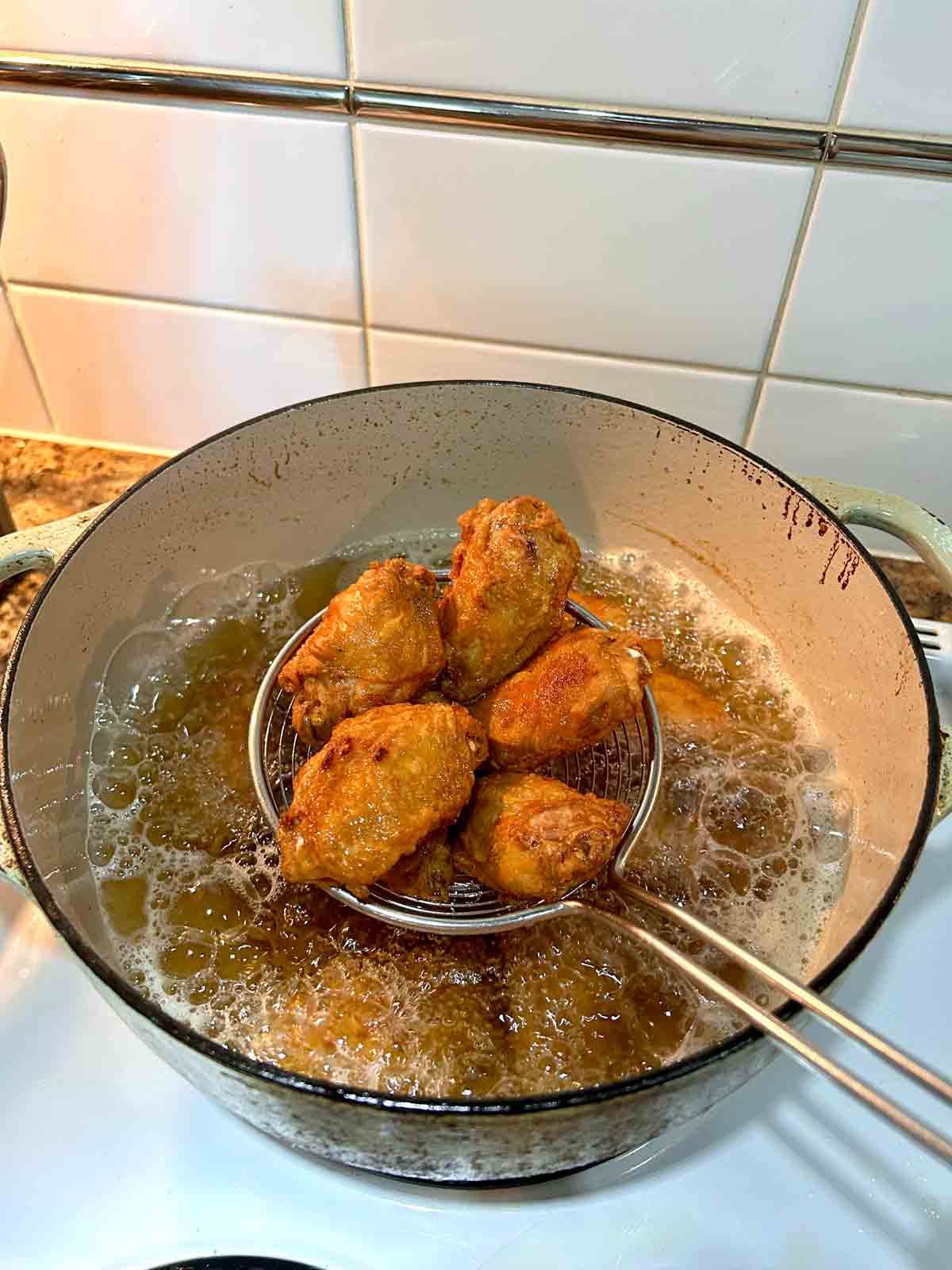 metal spider lifting fried wings out of hot oil.