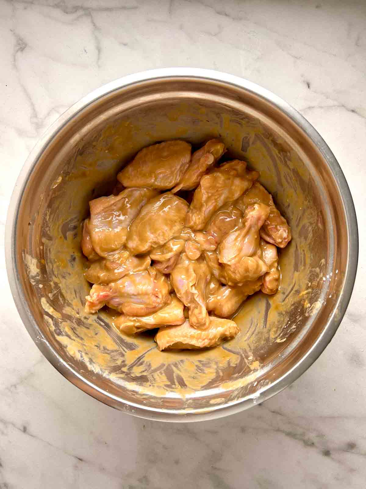 chicken wings marinating in bowl.
