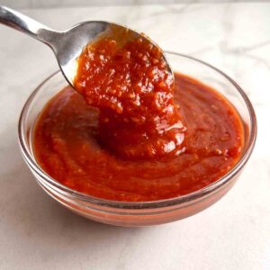 spoon lifting cocktail sauce from bowl.