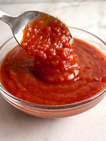 spoon lifting cocktail sauce from bowl.