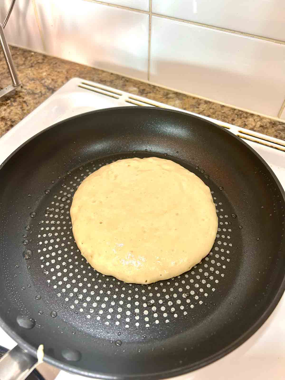 first side of batter cooking in pan.