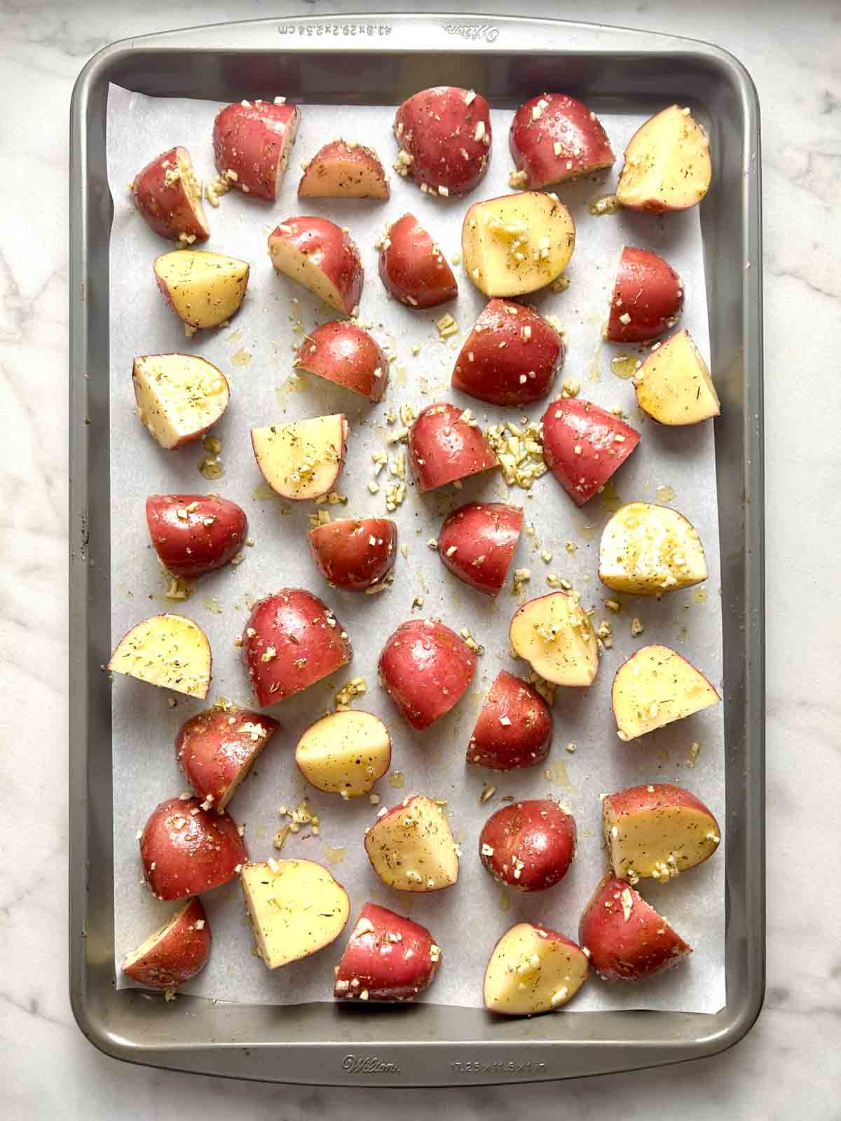 red potatoes seasoned and spread on pan.