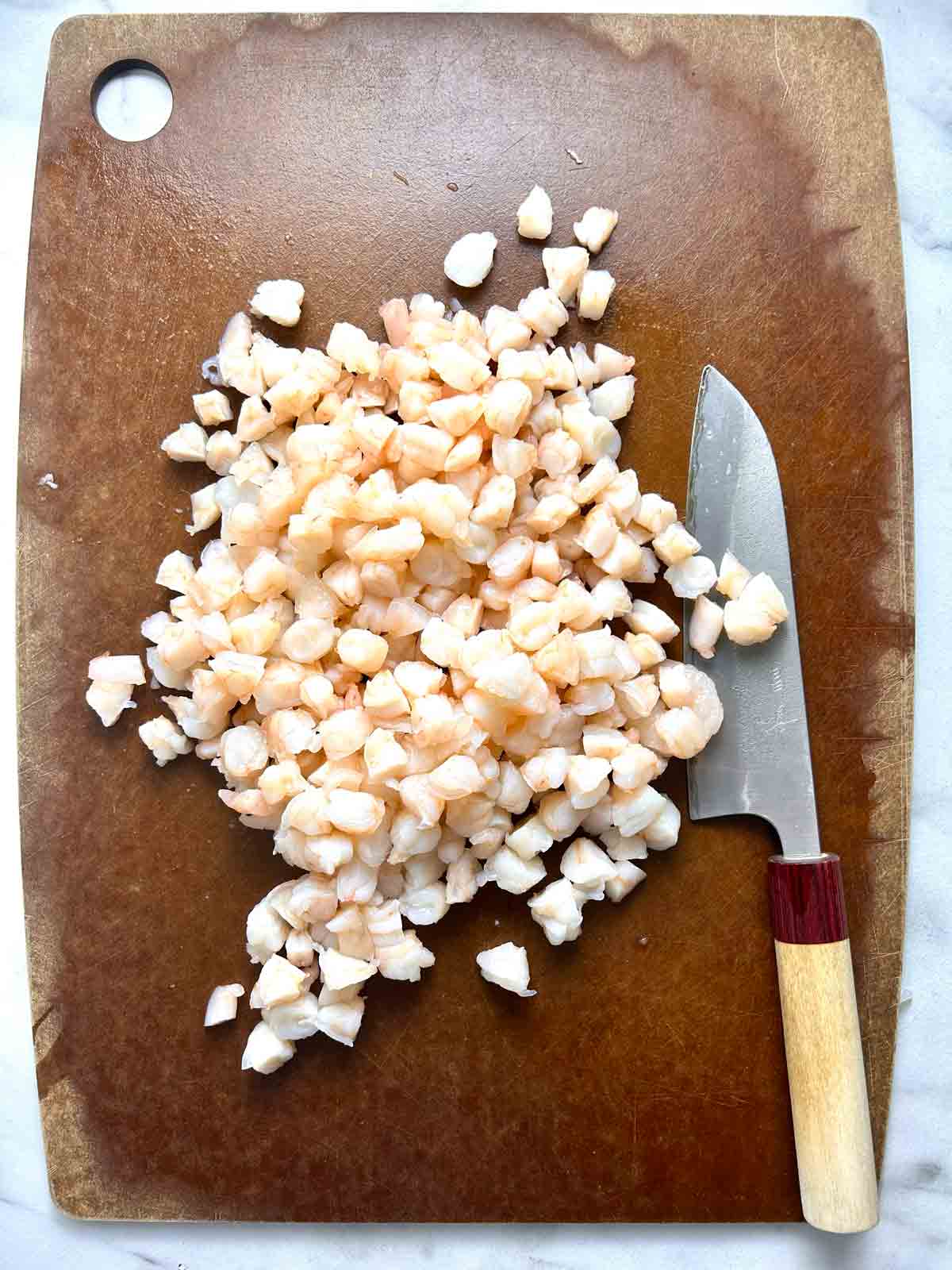shrimp chopped into small pieces on cutting board.