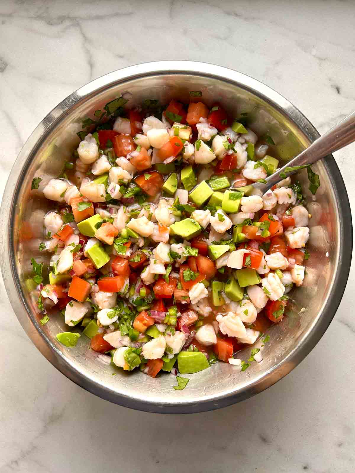 shrimp ceviche being mixed in bowl.
