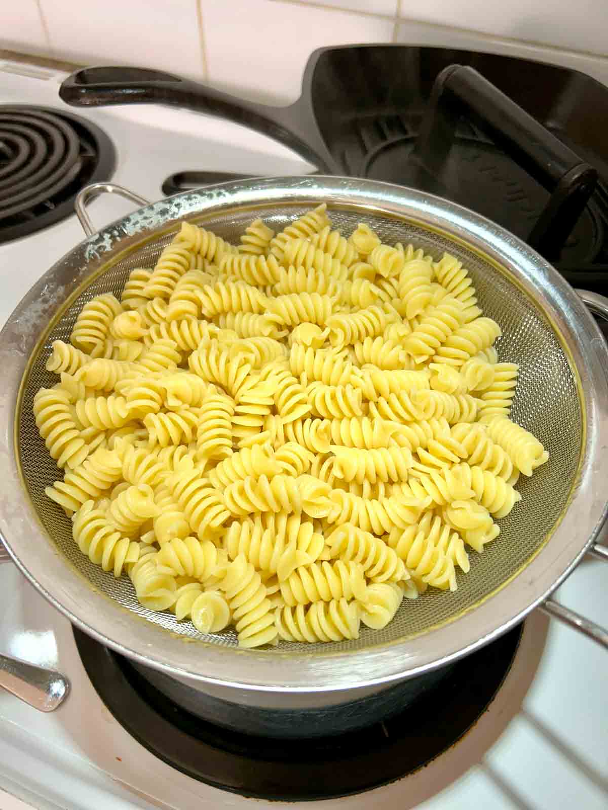 cooked pasta draining over pot.