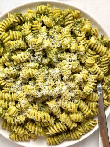 plate of pesto pasta with extra Parmesan cheese grated on top.