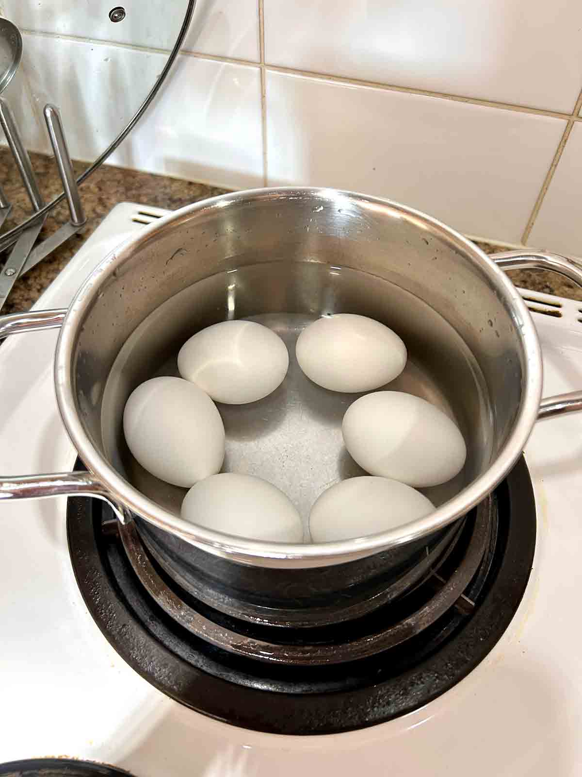 eggs boiling in pot of water.