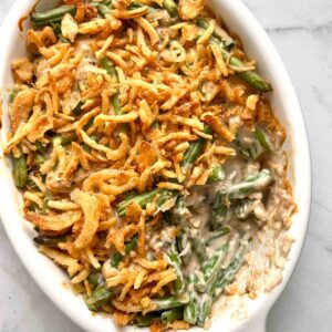 close up of green bean casserole with portion of it scooped out of baking dish.