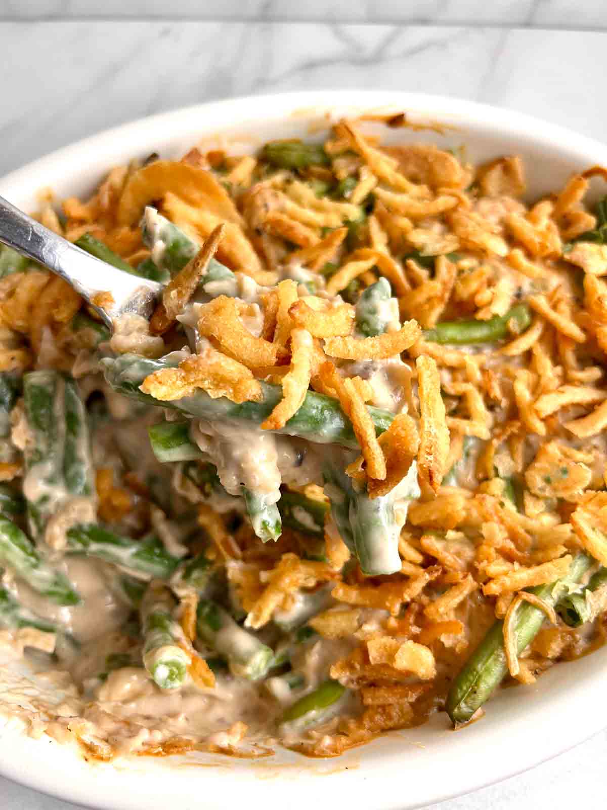 spoon scooping up casserole from pan.