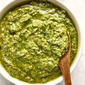 bowl of homemade pesto with spoon in it.