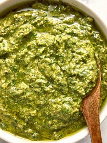bowl of homemade pesto with spoon in it.