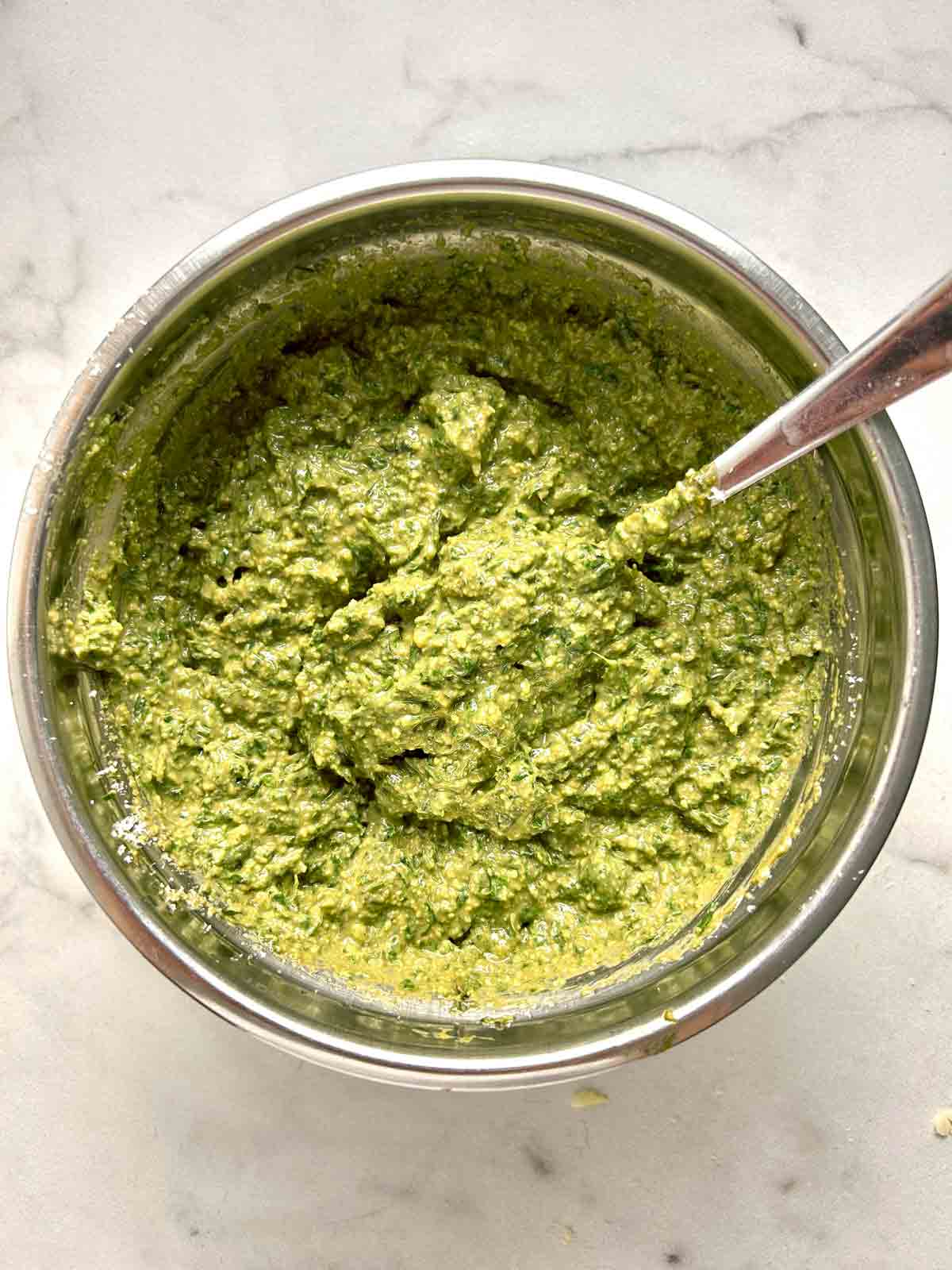 pesto in bowl with olive oil and parmesan mixed in.