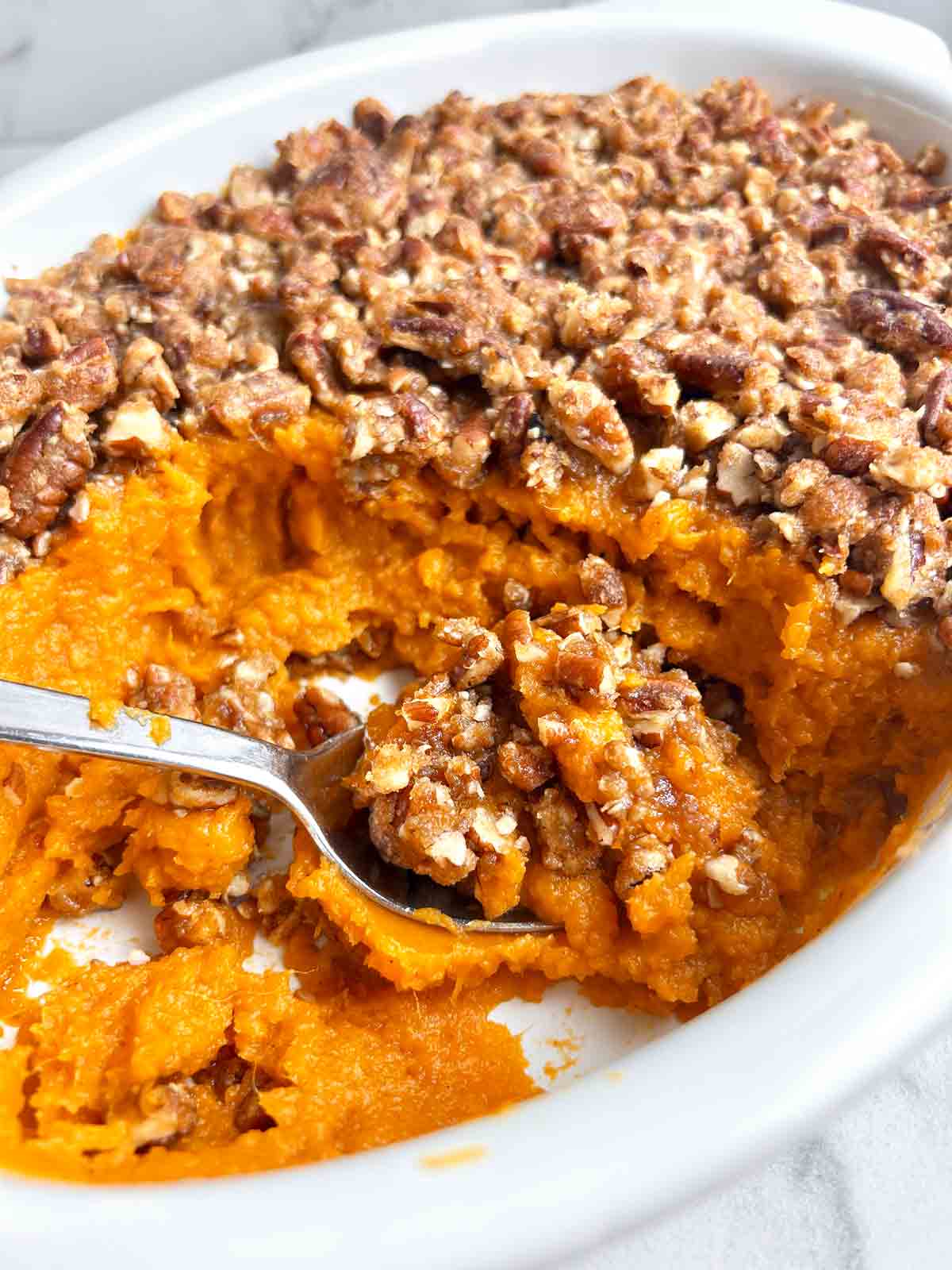 sweet potato casserole in baking dish with portion scooped out.